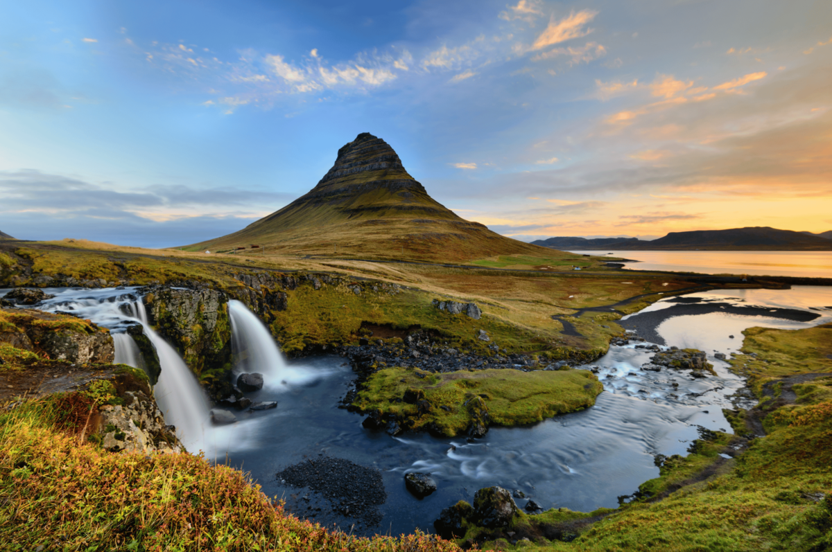 Malowniczy wodospad i góra Kirkjufell o zachodzie słońca na Islandii