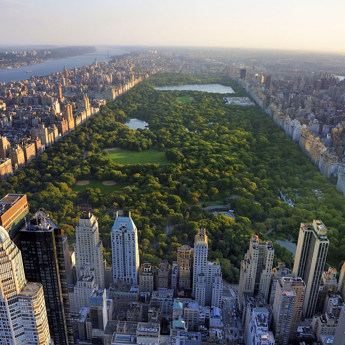 Widok z lotu ptaka na Central Park otoczony drapaczami chmur w Nowym Jorku przy zachodzie słońca